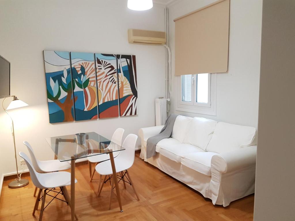 a living room with a white couch and a glass table at Errathens Apartments - Athens Center in Athens