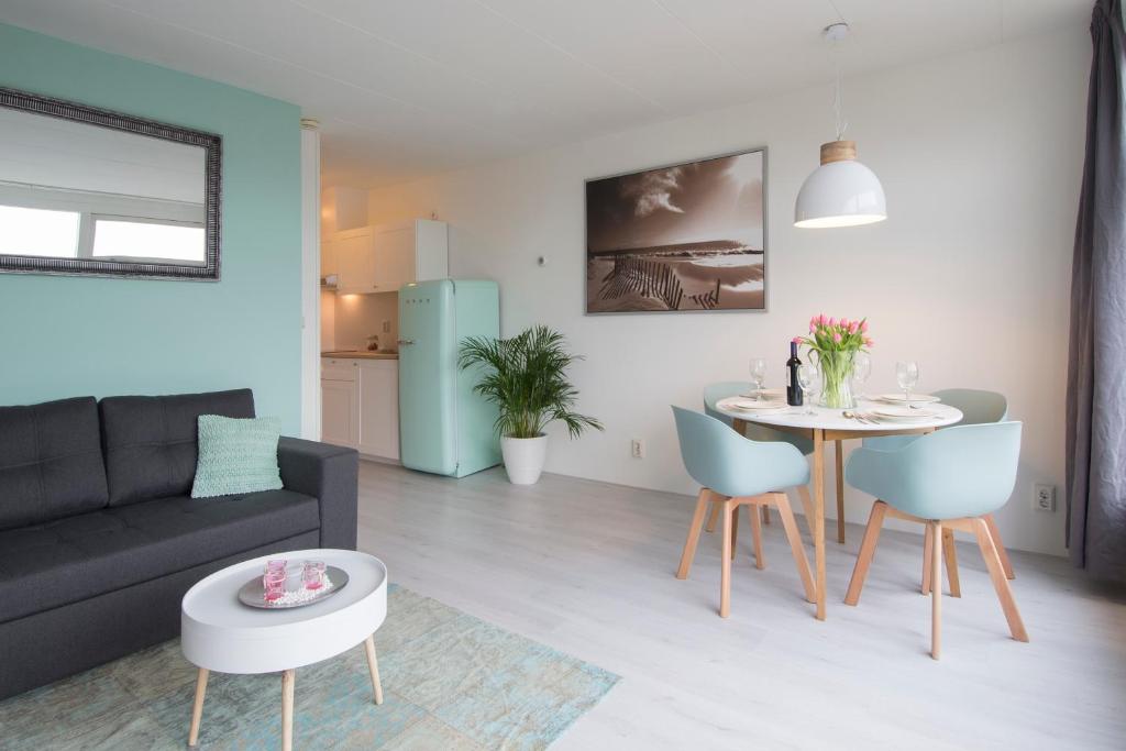 een woonkamer met een bank en een tafel bij Amsterdam Beach Apartment 80 in Zandvoort