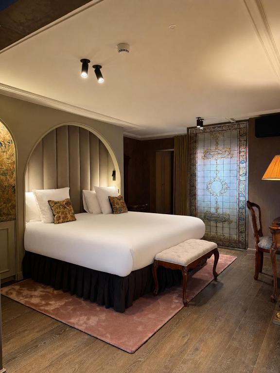 ein Schlafzimmer mit einem großen Bett und einem Stuhl in der Unterkunft Hotel Cour Saint Georges by CW Hotel Collection in Gent