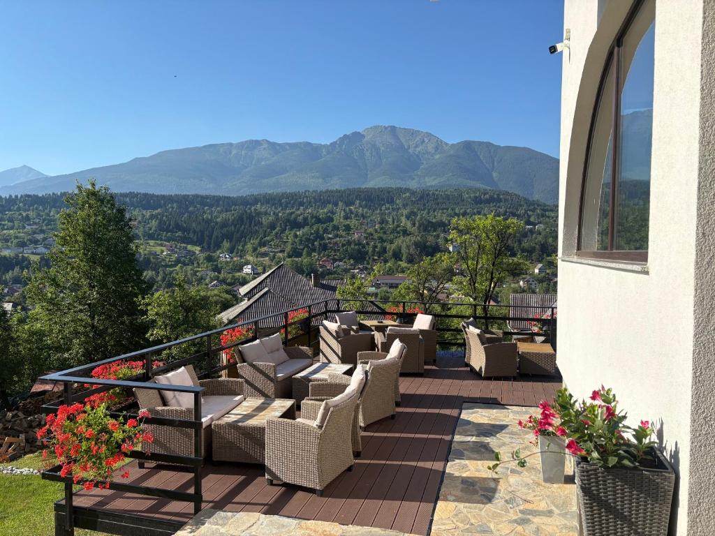ein Balkon mit Stühlen und Bergblick in der Unterkunft Liniștea Codrului in Borşa
