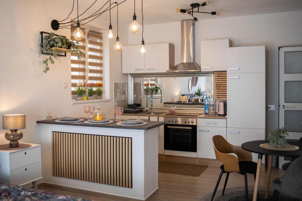 a kitchen with white cabinets and a counter top at Apartman NOA in Novska