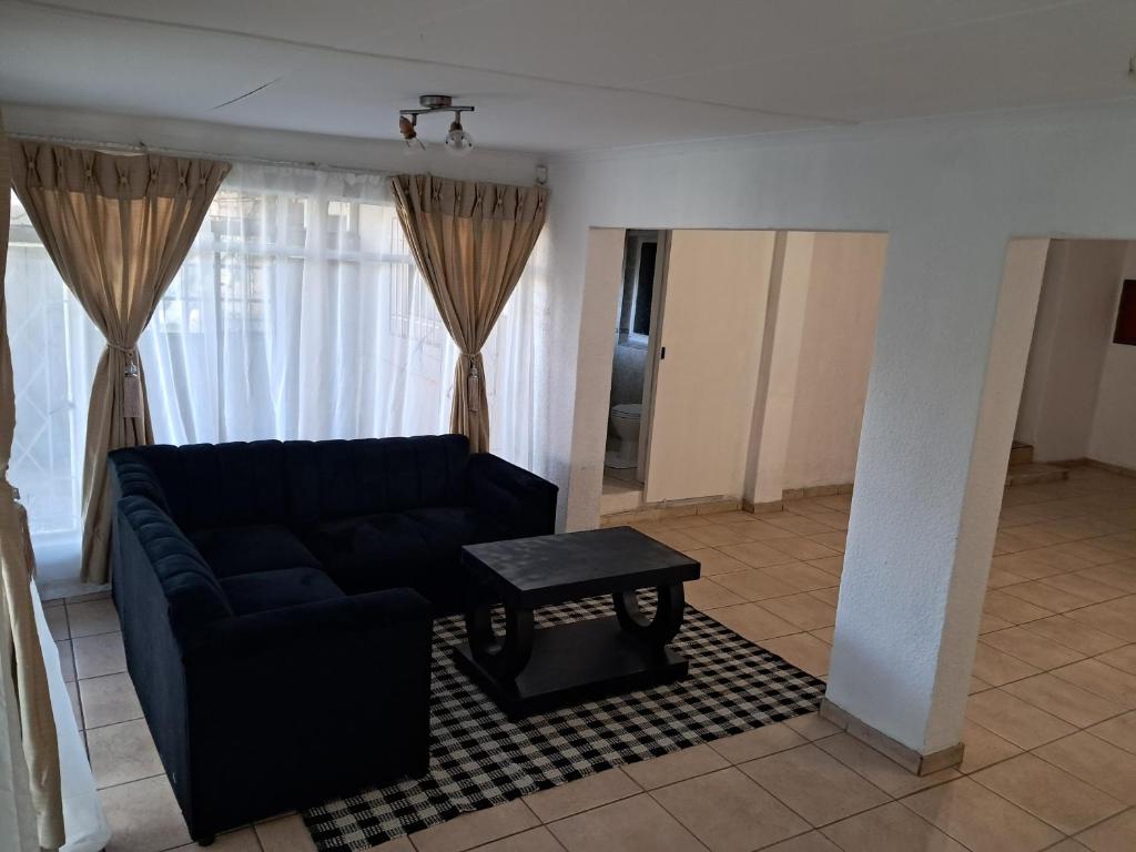 a living room with a couch and a table at Charles Guest House in Germiston