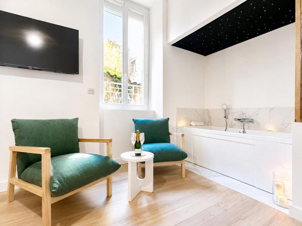 a living room with two chairs and a tub at Le SPA Étoilé - Baignoire Balnéo et Sauna Privatif in Mont-de-Marsan