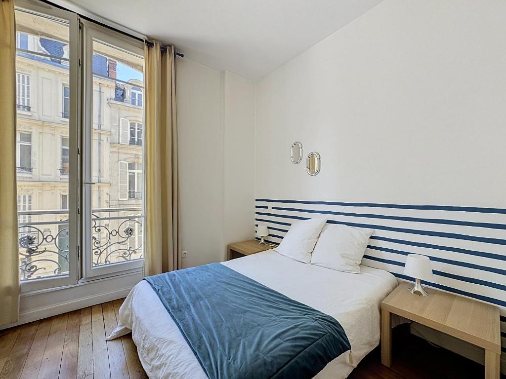 a bedroom with a bed and a large window at Le Cours Langlet B in Reims