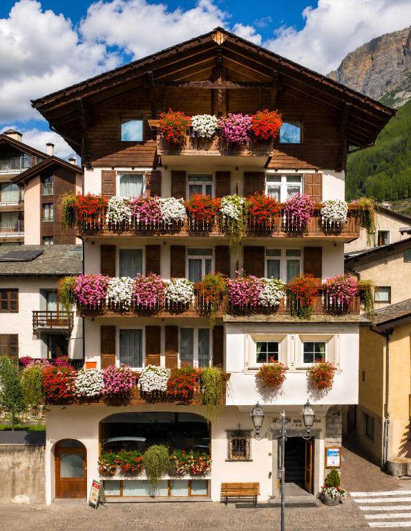 a building with lots of flower boxes on it at Hotel Meublè Garnì della Contea in Bormio