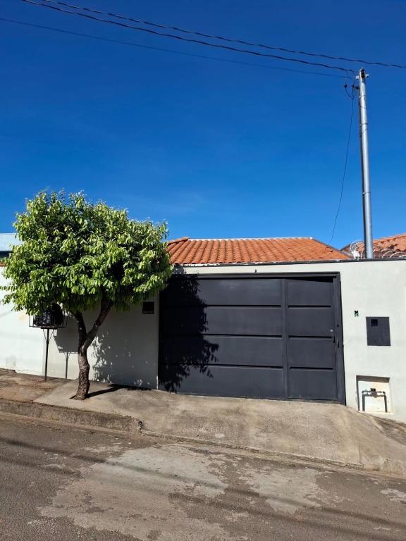 a garage door with a tree in front of a house at casa da Roberta SJB capitólio in São José da Barra