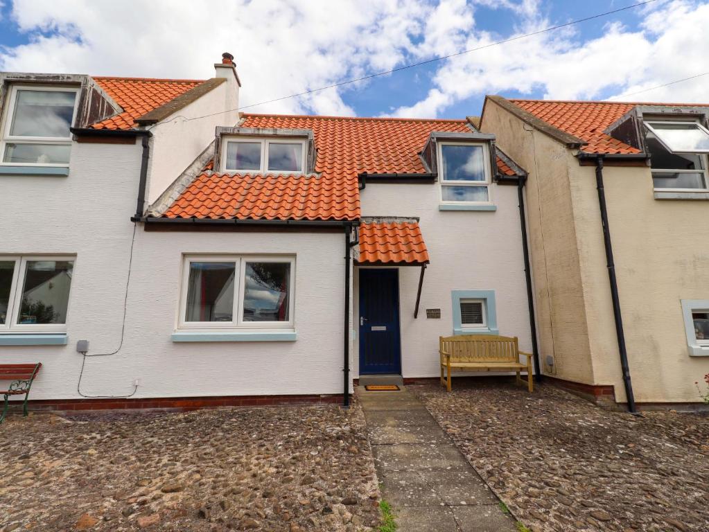 a white house with an orange roof at Sarah's Cottage in Berwick-Upon-Tweed