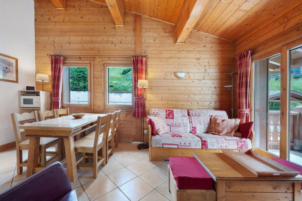 a living room with a couch and a table at Appartement Airelles B25 in Levassaix