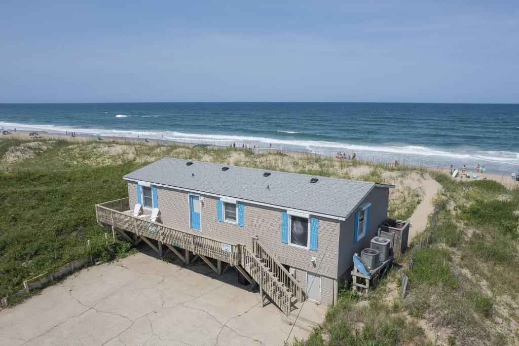 a house on the beach next to the ocean at 5010 - Once Upon A Tide in Kill Devil Hills