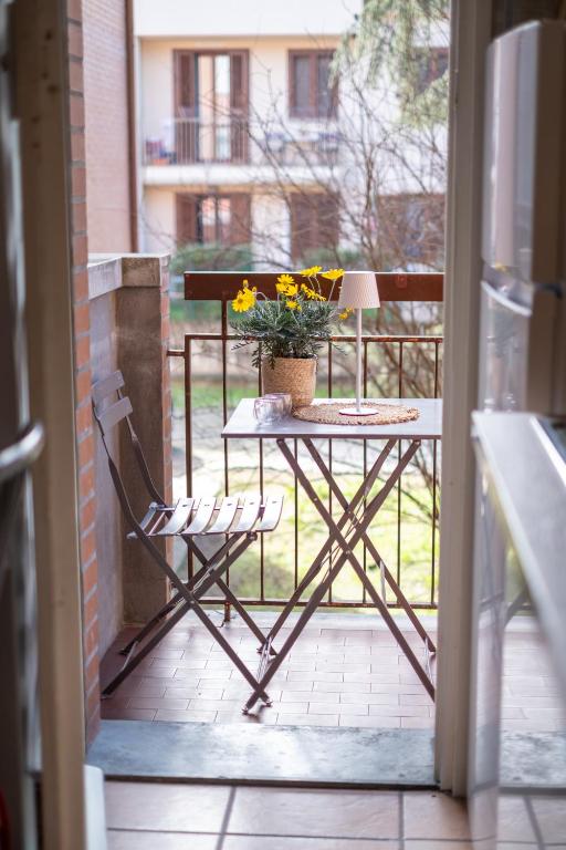 a table and a chair on a balcony with a plant at Landi 14 - Air Conditioning, Private Parking, Premium Sleep in Medicina