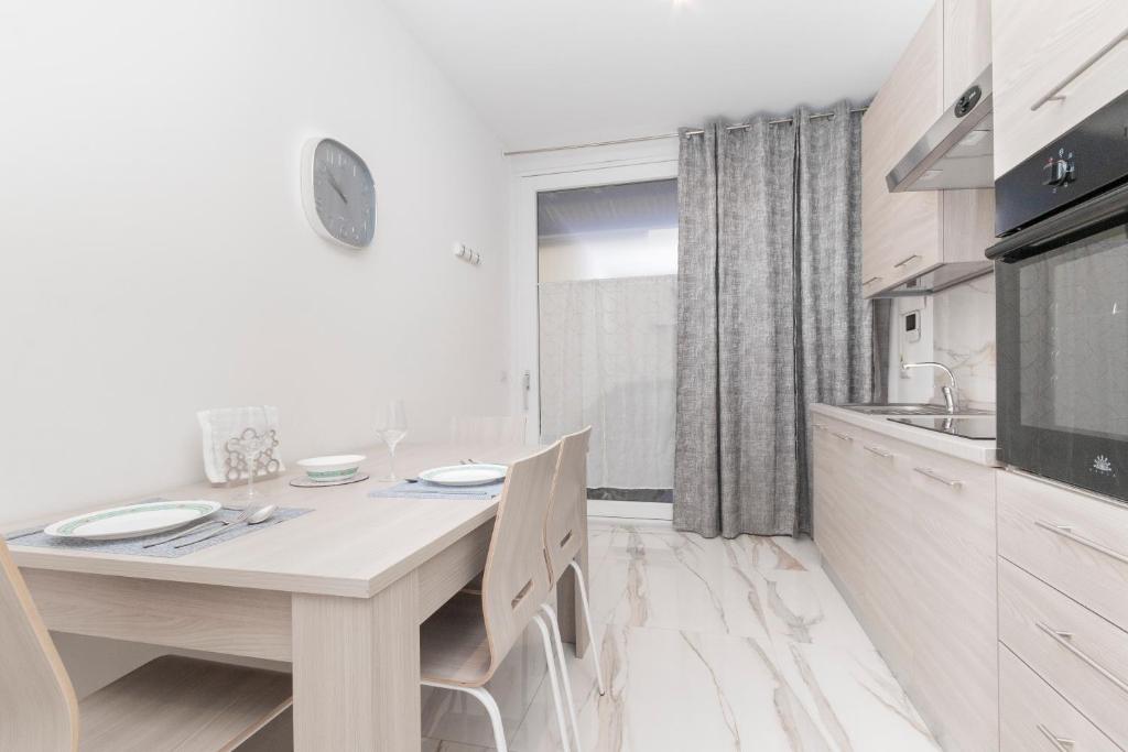 a white kitchen with a table and a sink at Molino Lounge Express 20' da Milano e Malpensa in Saronno