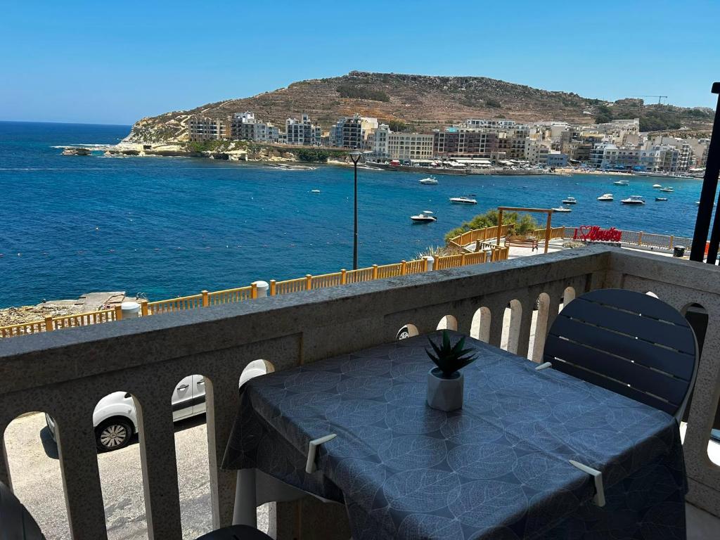 a table on a balcony with a view of the ocean at Excellent views in Marsalforn