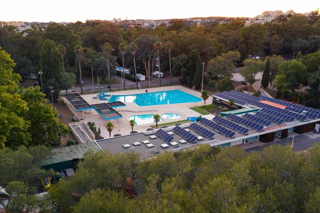 an overhead view of a swimming pool with chairs and a stadium at Kampaoh Lisboa in Lisbon