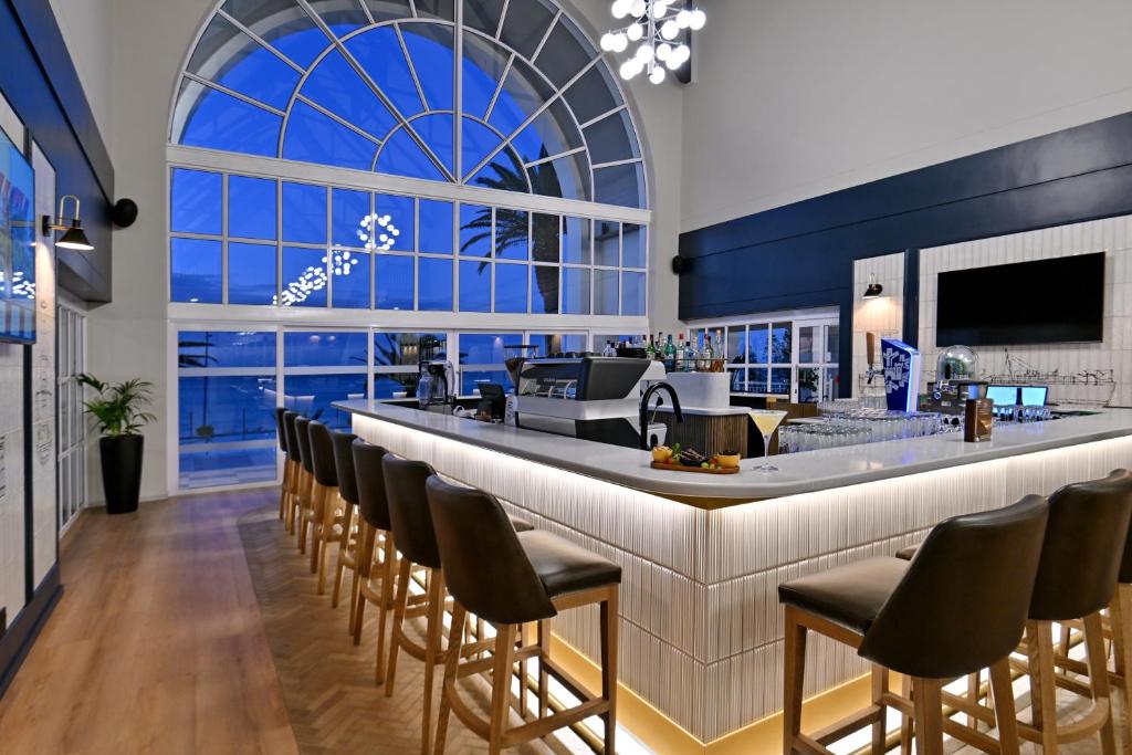 a bar in a restaurant with a large window at Courtyard Hotel Gqeberha in Port Elizabeth