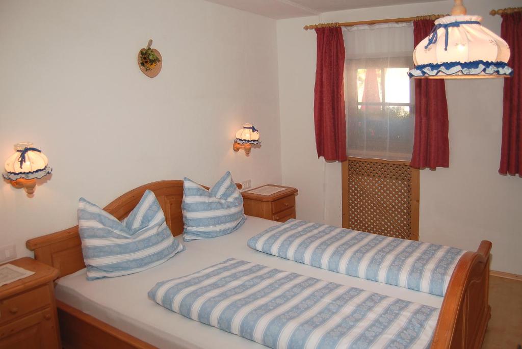 a bedroom with a bed with blue and white pillows at Vilahof in San Vigilio Di Marebbe