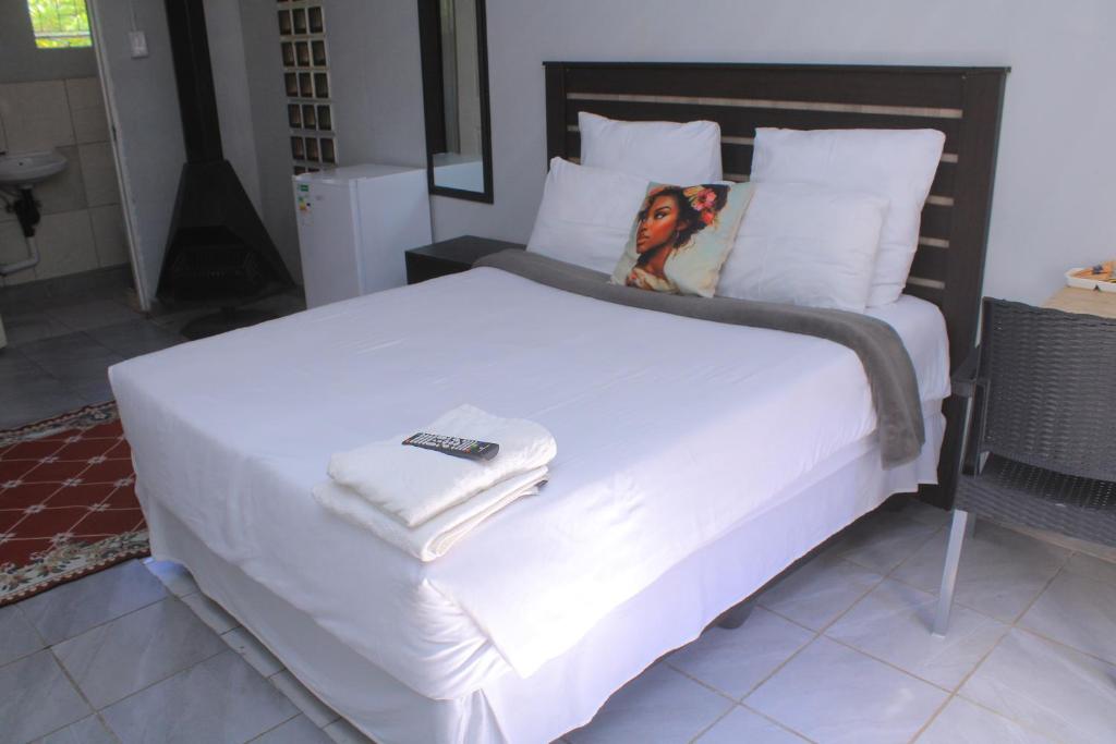 a bedroom with a large white bed with towels on it at Fargon Guest House in Polokwane