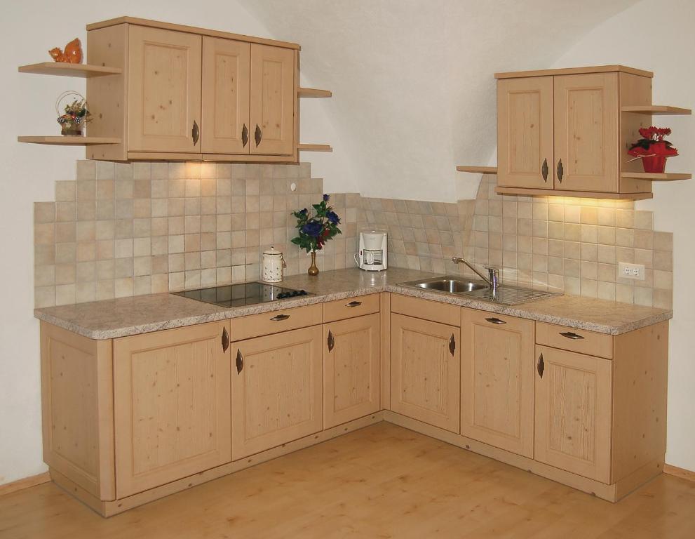 a kitchen with wooden cabinets and a sink at Vilahof in San Vigilio Di Marebbe