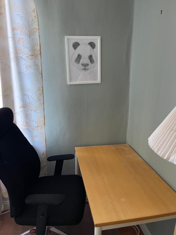 a desk with a chair and a picture of a panda at 5ans rum in Skellefteå