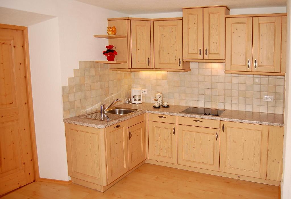 a kitchen with wooden cabinets and a sink at Vilahof in San Vigilio Di Marebbe