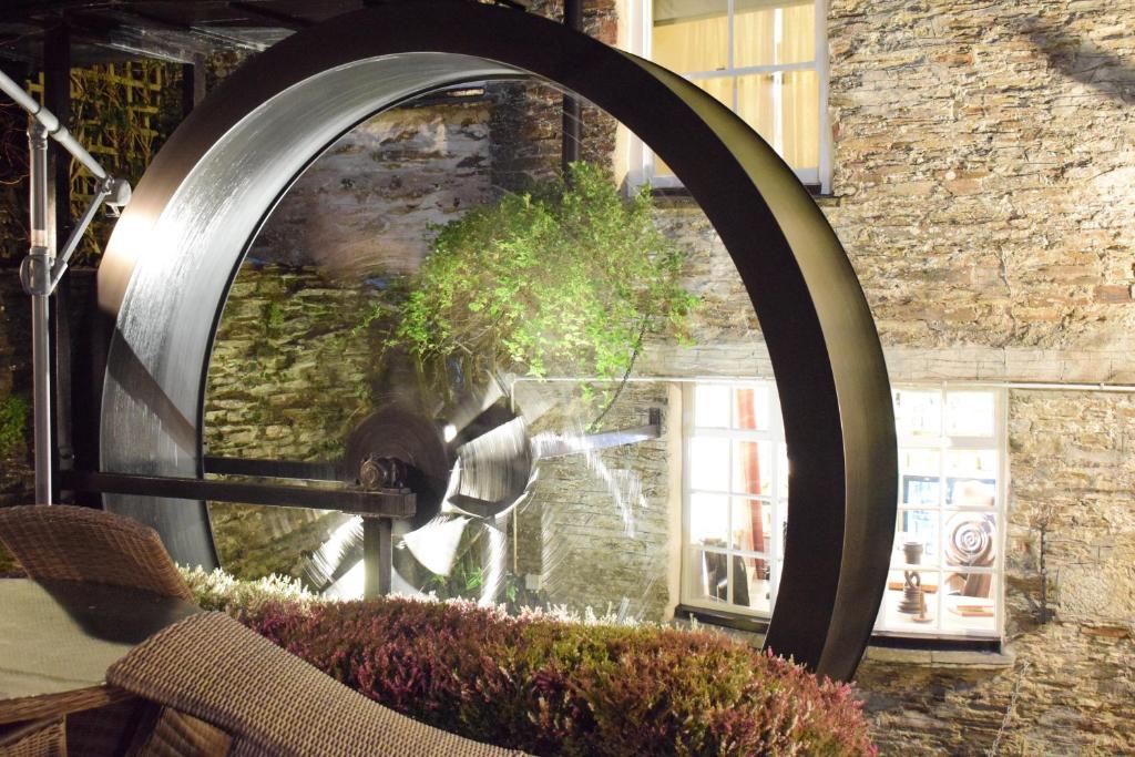 a large circular mirror in front of a window at The Old Mill House in Padstow