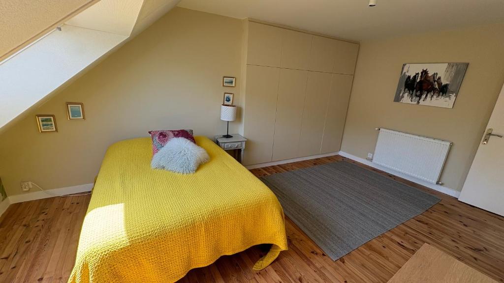 a bedroom with a bed with a yellow blanket at L'Atelier - Grande chambre d'hôtes in Caen