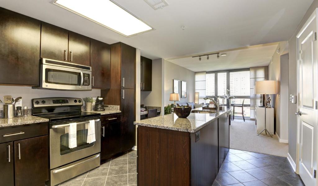 eine Küche mit Küchengeräten aus Edelstahl und ein Wohnzimmer in der Unterkunft National at Pentagon City in Arlington