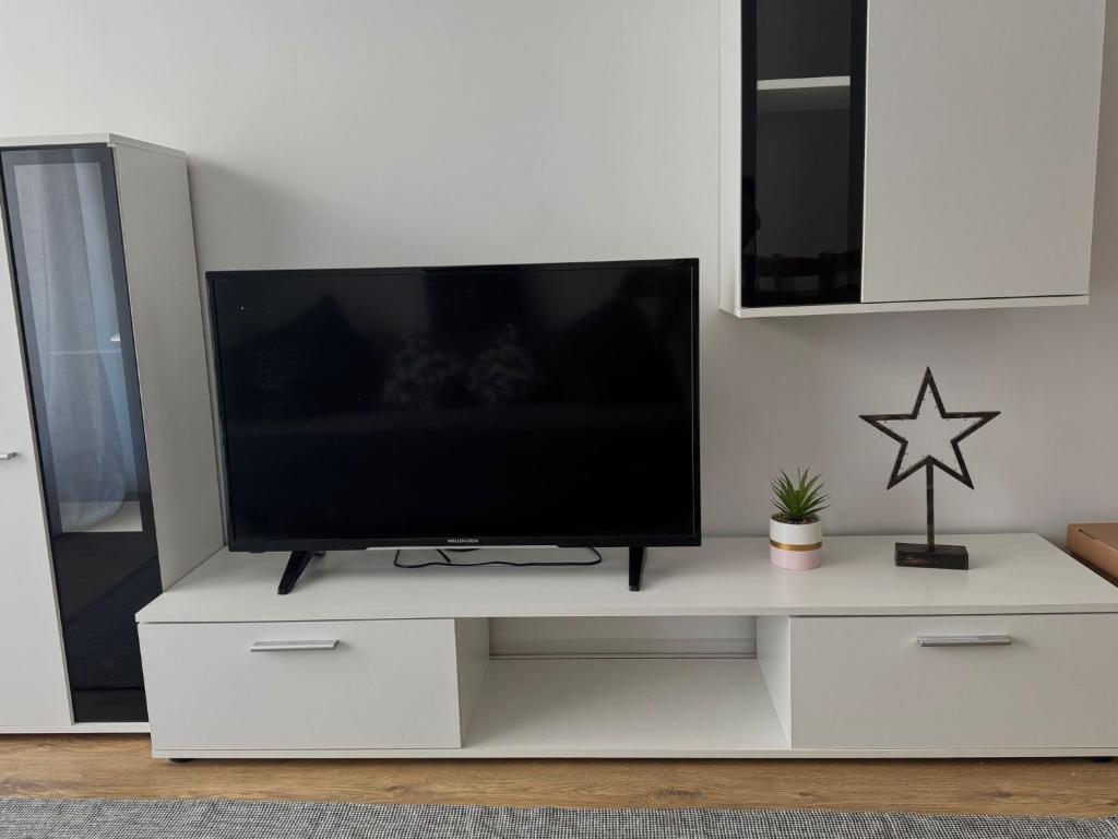 a white entertainment center with a flat screen tv on it at Studio Apartament Cosmopolis P3B in Ştefăneştii de Sus