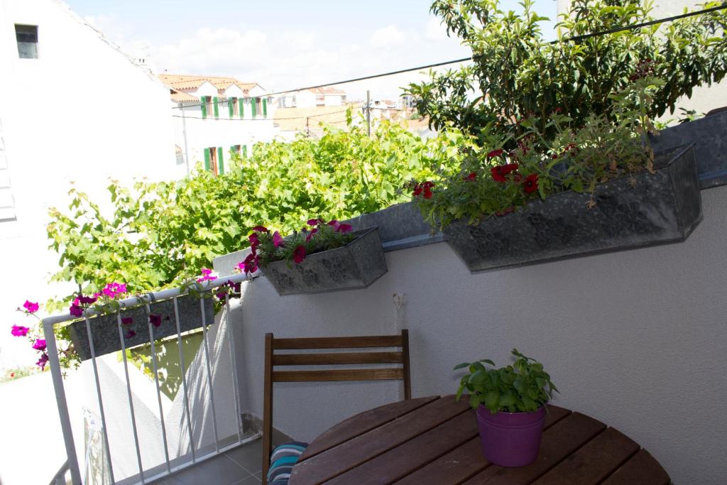a balcony with a wooden table and potted plants at Apartman Renata in Biograd na Moru