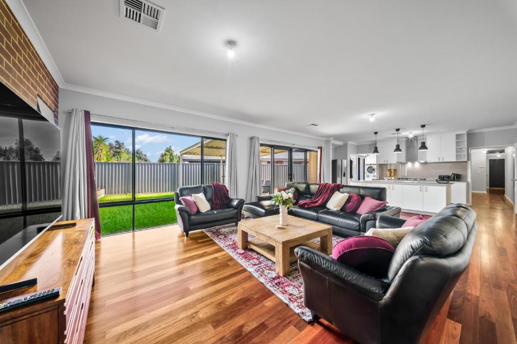 a living room with leather couches and a table at Nest in The Vines in The Vines