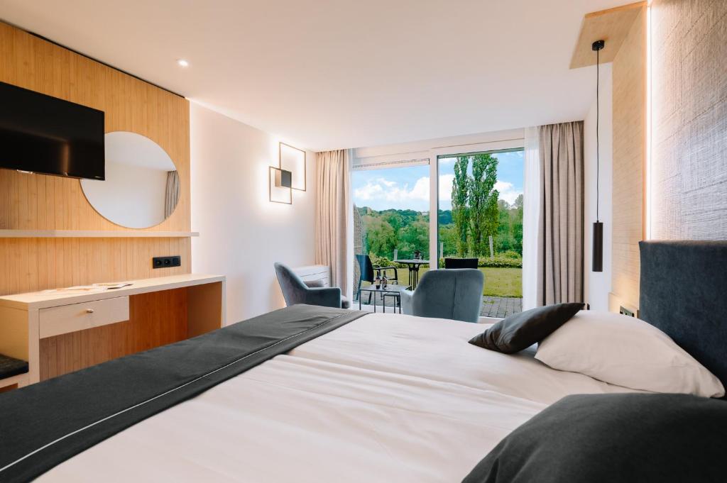 a hotel room with a bed and a large window at Hotel - Appartement de Zevende Heerlijkheid in Slenaken