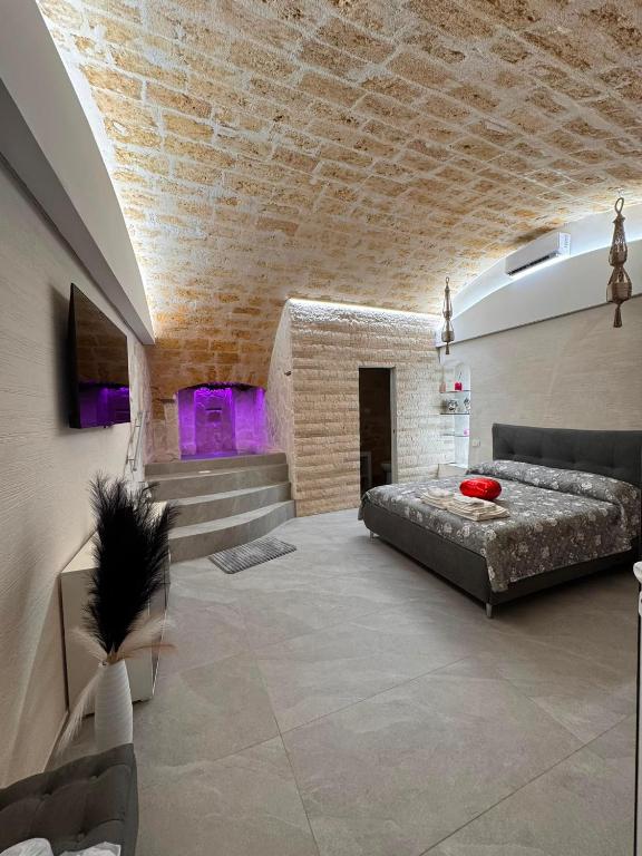 a bedroom with a bed and a brick wall at Twins Luxury Suite - Barletta in Barletta