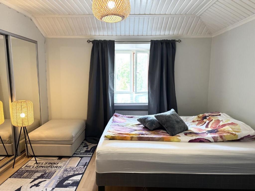 a bedroom with a bed with a window and a window at Rautatien ullakkohuoneisto in Karkkila