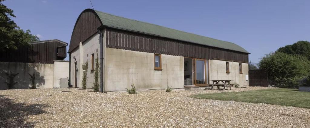 a large white building with a green roof at The Dutch Barn in Stratton Audley