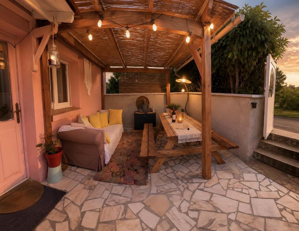 a patio with a wooden pergola and a couch at Maison Donarosa Charmant in Vieille-Brioude