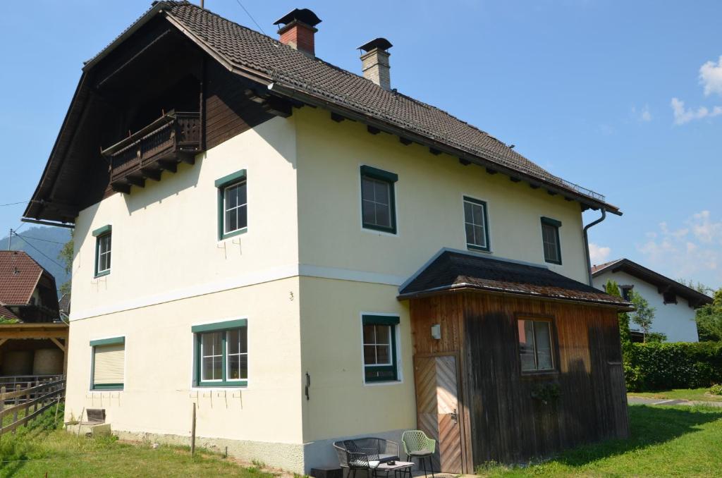 a large white house with a wooden garage at Gästehaus Manuela in Lind