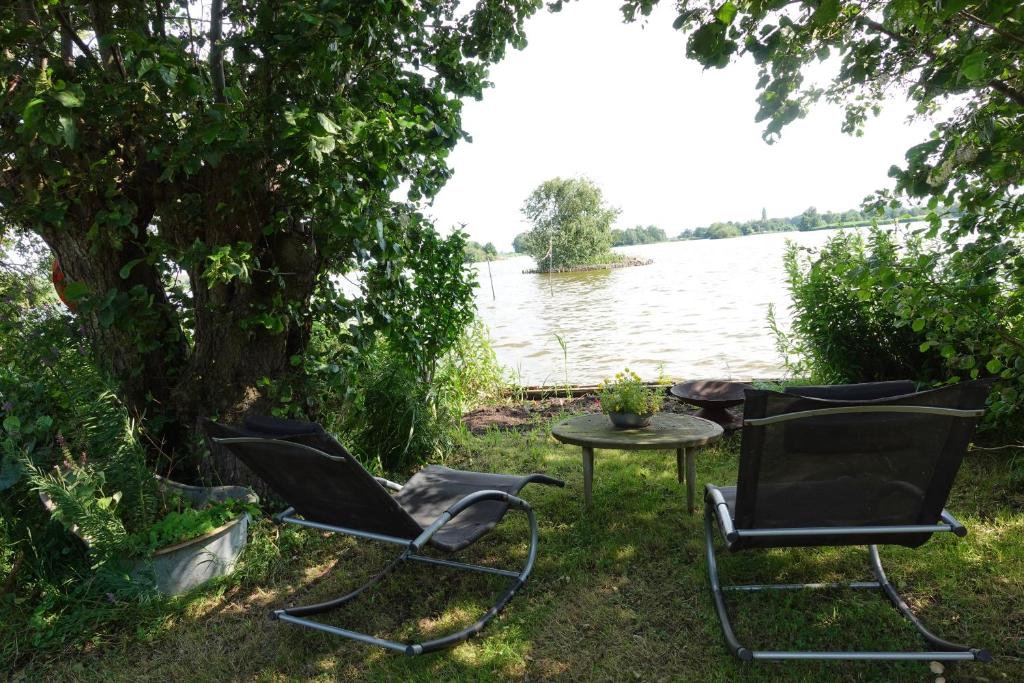 a group of chairs and a table next to a lake at Exceptional B&B in Reeuwijk