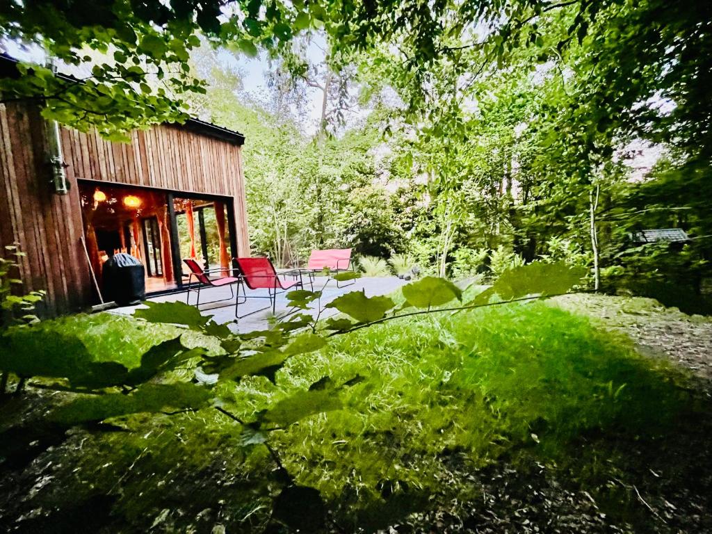 a house with red chairs and a patio at La Noisette in Florennes