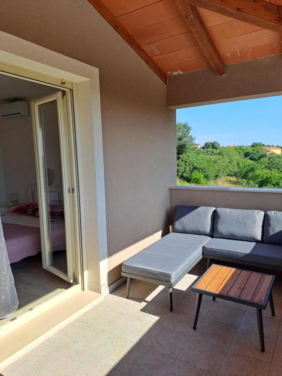 a patio with a couch and a table and a bed at Apartment Lucia in Marčana