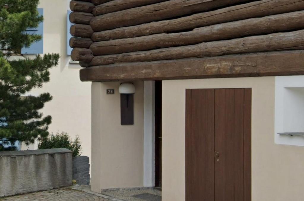 a building with a brown door on the side of it at Zimmer in Celerina in Celerina