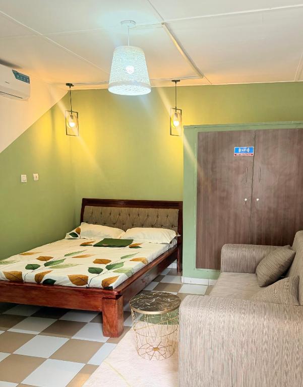 a bedroom with a bed and a couch at Studio Paisible Aéroport FHB in Abidjan