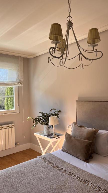 a bedroom with a bed and a chandelier at BenedettaMolinaseca VuT in Molinaseca