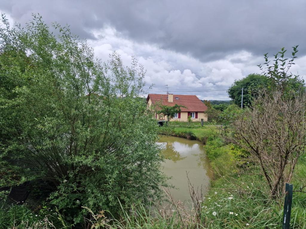 a house and a river in front of a house at Chez Peyrin in Labastide-Chalosse