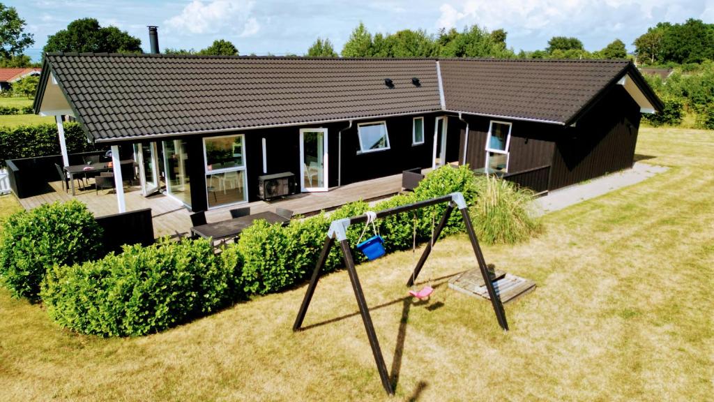 a small house with a swing in front of it at Holiday Home Als - Starfish in Nordborg