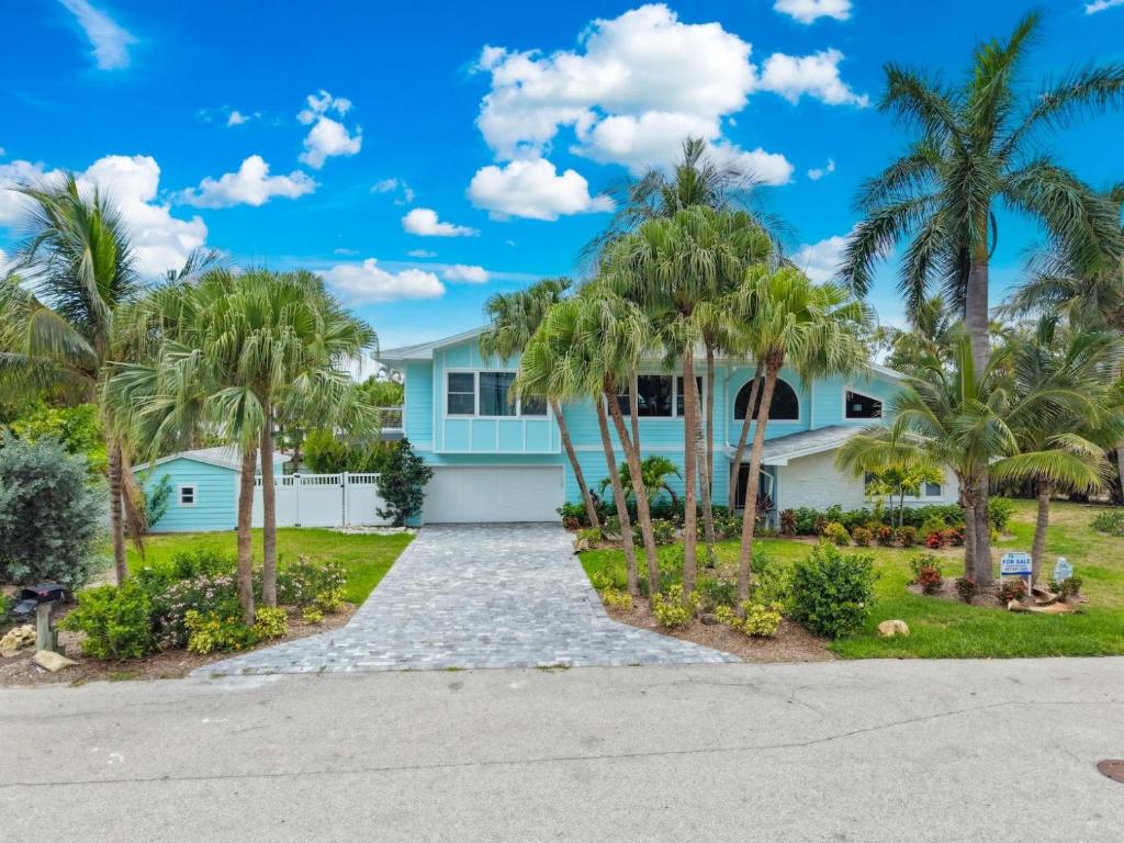 a house with palm trees in front of it at Salt Life Sanctuary in Sanibel