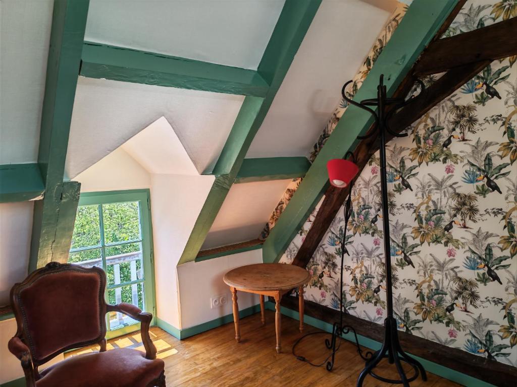 a room with a staircase with a table and a chair at Une chambre en Amazonie in Le Menoux