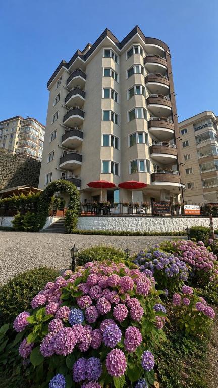 a large building with purple flowers in front of it at Borahan Hotel in Trabzon
