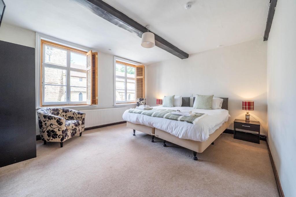 a bedroom with a large bed and a chair at Kings Arms Hotel in Cleobury Mortimer