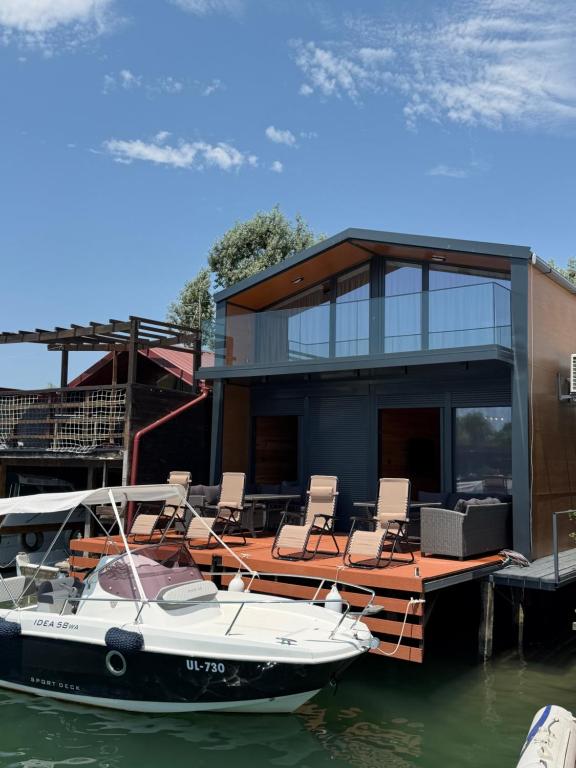 a boat sitting on the water in front of a house at NiL Cottage in Ulcinj