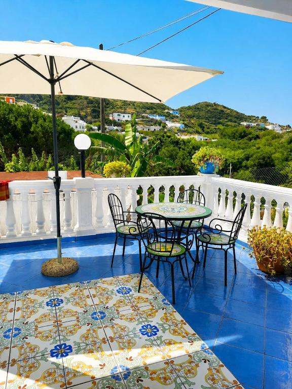 a patio with a table and chairs and an umbrella at Casa Simonetta Il Glicine in Ponza