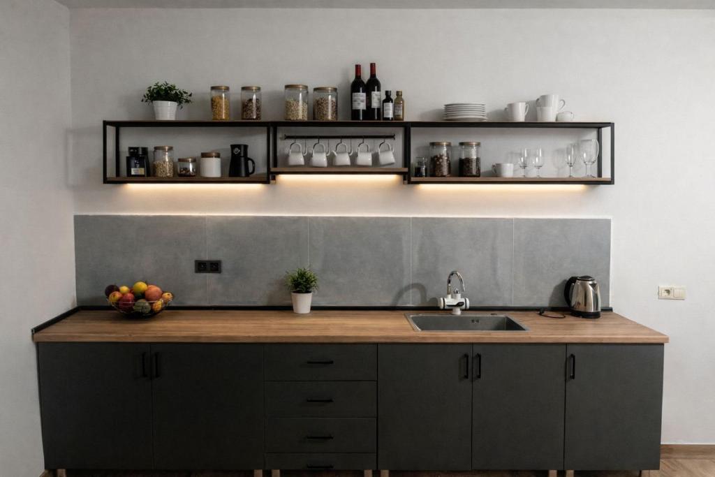 a kitchen with a counter with a sink and shelves at Tonir House in Goris